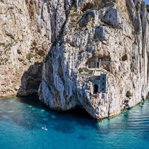 Old mining area in the rock above the turquoise sea in Sardinia, Italy. Porto Flavia