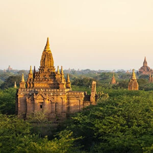 Old pagodas amidst trees against sky during sunrise, Bagan, Mandalay Region, Myanmar