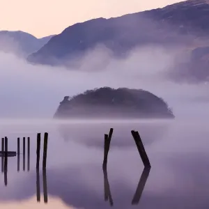 Old wooden jetty and St Herberts Island on Derwent Water at dawn on a misty Old wooden jetty and St Herberts Island on Derwent Water at dawn on a misty