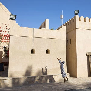 An Omani boy jumps to catch a ball in Bahla Fort, Tanuf, Oman