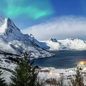 Panoramic of snowy mountains and cold sea under the Northern Lights, Mefjorden, Senja, Troms county, Norway Panoramic of snowy mountains and cold sea under the Northern Lights, Mefjorden, Senja, Troms county, Norway