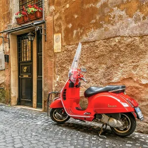 Moto de Vespa roja estacionada en una calle empedrada de Roma, Lacio, Italia Moto de Vespa roja estacionada en una calle empedrada de Roma, Lacio, Italia