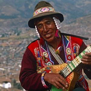 Peru, Cusco. An itinerant Quechuan musician plays his bandurria in the hills above Cusco