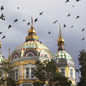Pigeons flying over Zenkov Cathedral, Almaty, Kazakhstan