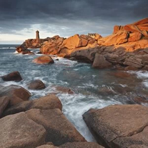 Pink Granite coast, Brittany, France. The Ploumanach lighthouse (Men Ruz) an sunset