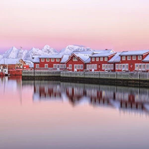 Pink sunset over the typical red houses reflected in the sea