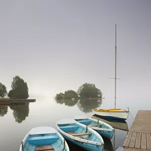 Pleasure boats moored at Llangorse Lake on a misty morning, Brecon Beacons National Park