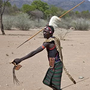A Pokot warrior wearing a leopard skin cape celebrates an Atelo ceremony, spear in hand