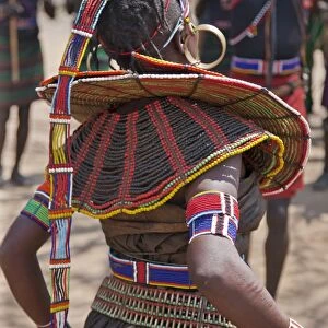 A Pokot woman in traditional attire dances to celebrate an Atelo ceremony