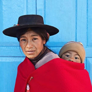 Portrait of an Aymara mother in traditional clothes with her child standing in front of