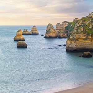 Portugal, Algarve, Lagos; Praia da Dona Ana, woman sitting on beach (MR)
