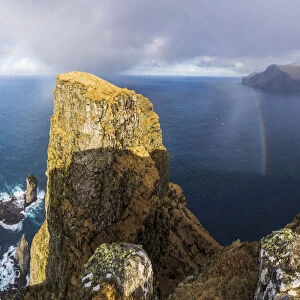 A whole rainbow above Risin og Kellingin sea stacks and Eiðiskollur, a 343 meter high cliff near the village of Eiði. Eysturoy, Faroe Islands
