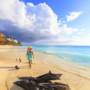 Rear view of woman with hat walking on Ffryes Beach, Antigua, Antigua and Barbuda