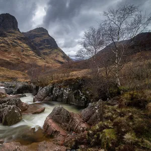 River Coe rushing through Glencoe valley beneath the Three Sisters mountains, Highlands, Scotland, UK. Spring (March) 2023