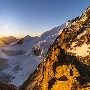 The rocks of Dirrunhorn and glacier of Nadelhorn peak at sunrise from Nadelgrat ridge
