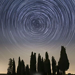 The rotation of the stars around Polaris, near the iconic Cypresses of San Quirico d