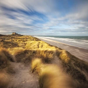 Sand dunes and Bamburgh Castle, Northumberland, England, UK