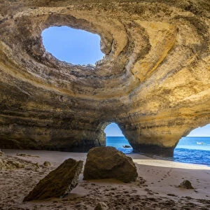 The sea caves of Benagil with natural windows on the clear waters of the Atlantic