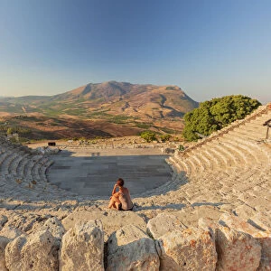 Segesta, Sicily. A woman sitting alone in the greek theater of Segesta at sunset