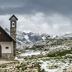 Small mountain church in the Dolomites after a summer snowfall, Cadore, Veneto, Italy