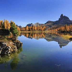 Small rock island emerging from Lago Federa lake with Becco di Mezzoda in the background