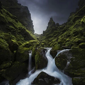 A small stream running through a lush green canyon in summer, Southern Iceland
