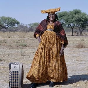 A smartly dressed Herero woman waits for a bus