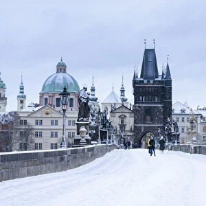 Snow-covered Charles Bridge and Old Town Bridge Tower in winter, Prague, Bohemia