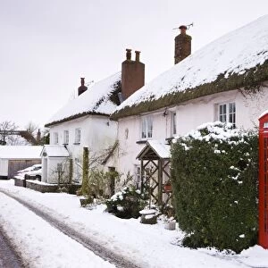 Snow covered cottages and traditional phone box in the village of Morchard Bishop