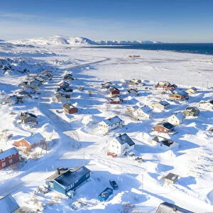 Snow covering the fishing village of Berlevag by the arctic sea, aerial view
