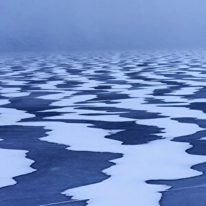 Snow textures shaped by the wind on a frozen lake in the Lofoten islands, Norway