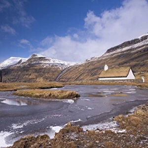Spectacular mountain scenery surrounding Saksuns pretty turf roofed church, Streymoy