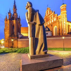 A Statue of the Polish Poet Adam Mickiewicz in front of St. Anne's Church and the Church of St. Francis and St. Bernard at Dusk, Vilnius, Lithuania A Statue of the Polish Poet Adam Mickiewicz in front of St. Anne's Church and the Church of St. Francis and St. Bernard at Dusk, Vilnius, Lithuania