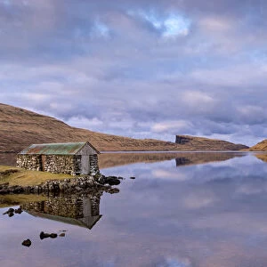 Stone boathouse on the shores of Lake Sorvagur on the island of Vagar, Faroe Islands, Denmark, Europe. Spring (April) 2016