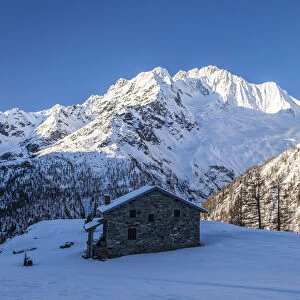 Stone hut at the foot of the snowy Monte Vazzeda, Alpe dell Oro, Valmalenco