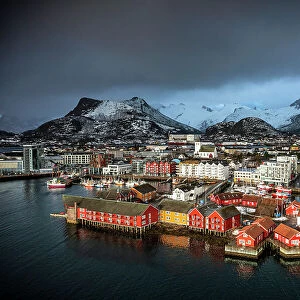 Storm clouds in the foggy sky over the snowcapped mountains surrounding Svolvaer, aerial view, Lofoten Islands, Norway