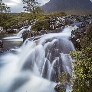 Stream flowing through rocks against Buchaille Etive Mor mountain in Glen Coe, Highland