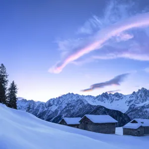 Stunning clouds above huts at sunrise. Soglio, Bregaglia Valley, Canton of Grisons