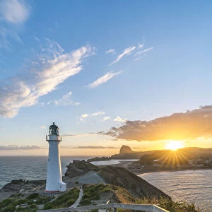 The sun is setting down behind Castle Rock and Castlepoint lighthouse. Castlepoint