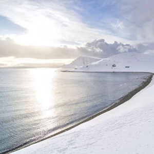 Sunlight reflected in the cold sea surrounded by snow, Skarsvag, Nordkapp