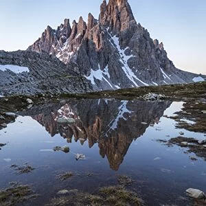Sunrise of Mount Paterno reflected in a puddle, Natural Park Three Peaks, Sesto Pusteria