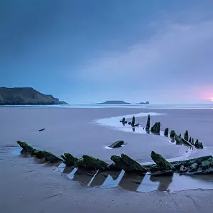 Sunset over the shipwreck of the Helvatia on Rhossili Bay, Gower, South Wales, UK. Spring (March) 2022