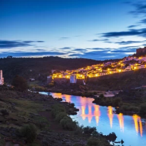 Sunset view over Guadiana River to old town with castle, Mertola, Alentejo, Portugal