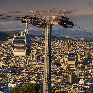 Teleferic de Montjuic or aerial tramway with city skyline at sunset, Barcelona, Catalonia