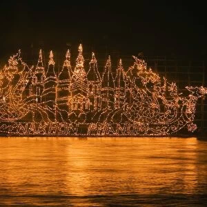 Thailand, Nakhon Phanom, That Phanom. A Fire Boat drifts on the Mekong River during the Illuminated Boat Procession. The fire boats are giant bamboo towers decorated with lanterns in religious motifs to celebrate the end of the Buddhist