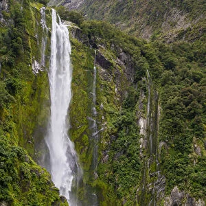 Tourist boat approaching Stirling Falls in Milford Sound in Fiordland National Park