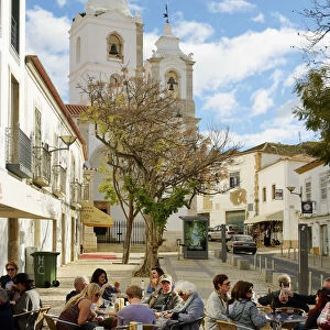 Tourists at a cafe and the church of Santo Antonio. Lagos Portugal