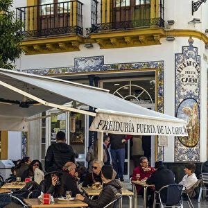 Tourists seated at tables outside a tapas bar in Seville, Andalusia, Spain