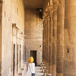 toursit walking through the Temple of Philae on an island in Lake Nasser, Nile River