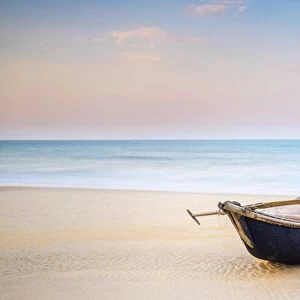 Traditional bamboo basket fishing boat on the beach at sunset, Thuan An Beach, Phu Vang District